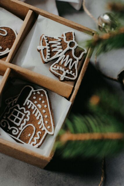 A close up of a corner of a box of Christmas cookies with white icing. 